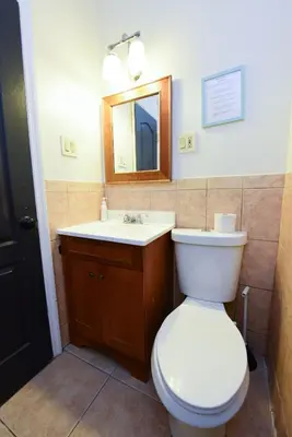 a bathroom with a toilet and a sink and a mirror at Great! Private NYC Room in Sunnyside in Haberman