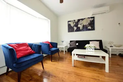 a living room with blue chairs and a white table at Great! Private NYC Room in Sunnyside in Haberman