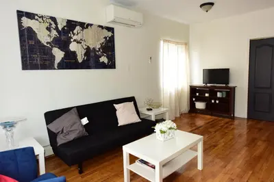 a living room with a black couch and a white table at Great! Private NYC Room in Sunnyside in Haberman
