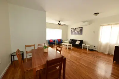 a dining room and living room with a wooden table at Great! Private NYC Room in Sunnyside in Haberman
