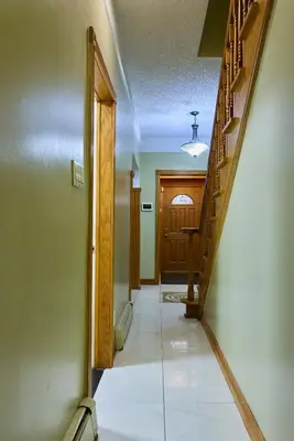 an empty hallway with a staircase and a door at Sweet Home - Zoller Stays in Long Island City