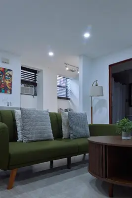 a green couch in a living room with a table at City Gem in Long Island City