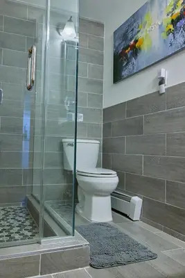a bathroom with a toilet and a glass shower at City Gem in Long Island City