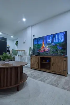a living room with a large flat screen tv at City Gem in Long Island City