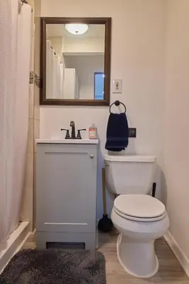a bathroom with a toilet and a sink and a mirror at City Gem in Long Island City