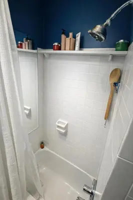 a bathroom with a tub and a white tiled wall at Next to Manhattan 2 Bedrooms Apartment - Subway 20 steps, Manhattan 1 Stop in Roosevelt Island