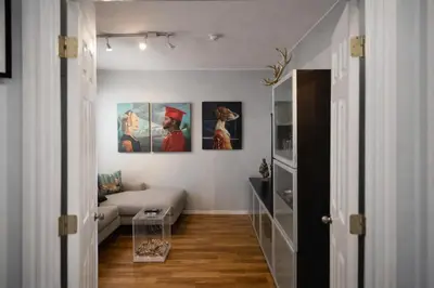 a living room with a couch and paintings on the wall at Next to Manhattan 2 Bedrooms Apartment - Subway 20 steps, Manhattan 1 Stop in Roosevelt Island
