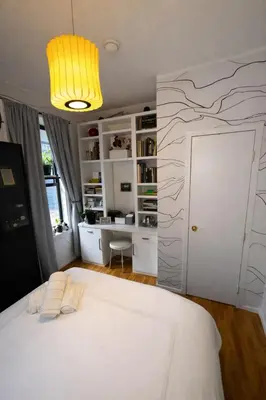 a bedroom with a white bed and a desk at Next to Manhattan 2 Bedrooms Apartment - Subway 20 steps, Manhattan 1 Stop in Roosevelt Island