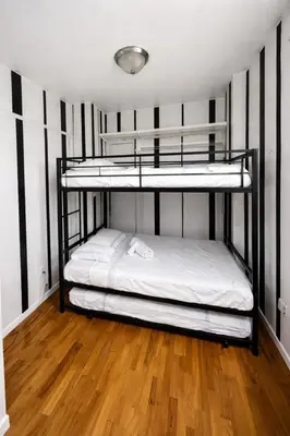 two bunk beds in a room with a wooden floor at Next to Manhattan 2 Bedrooms Apartment - Subway 20 steps, Manhattan 1 Stop in Roosevelt Island
