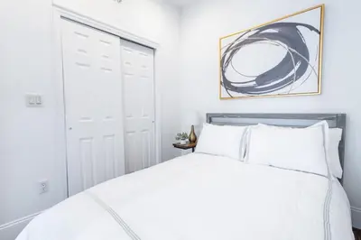 a white bedroom with a bed and a closet at 69-5C Festive Comfort Brand New 1BR Lower East Side Christmas Ready in New York