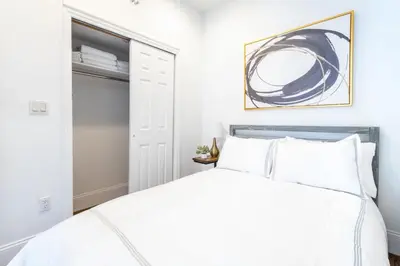 a bedroom with a white bed and a closet at 69-5C Festive Comfort Brand New 1BR Lower East Side Christmas Ready in New York