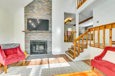 a living room with two red chairs and a fireplace at Ski, Hike and Golf Pet-Friendly Windham Retreat in Windham