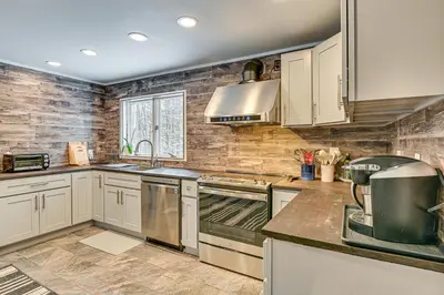 a kitchen with white cabinets and a stove top oven at Ski, Hike and Golf Pet-Friendly Windham Retreat in Windham