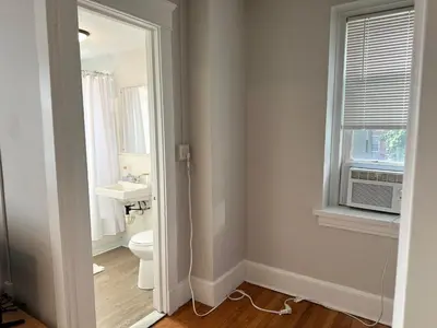 a bathroom with a toilet and a sink and a window at Serene Nordic Escape Close to Yale in New Haven