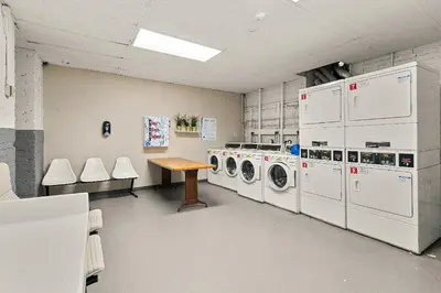 a laundry room with washing machines and a wooden table at Serene Nordic Escape Close to Yale in New Haven