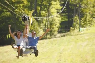 a man and woman are riding on a swing at Mountain View Suite at Jiminy Peak - Ski On Off - Near Elevator Pool and Lobby in Hancock