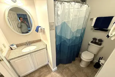 a man taking a picture of a bathroom with a shower at Mountain View Suite at Jiminy Peak - Ski On Off - Near Elevator Pool and Lobby in Hancock