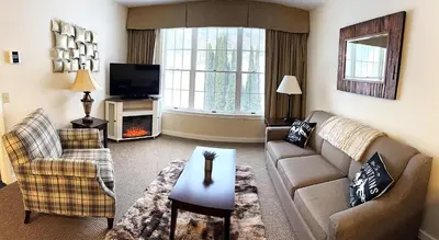 a living room with a couch and a tv at Mountain View Suite at Jiminy Peak - Ski On Off - Near Elevator Pool and Lobby in Hancock