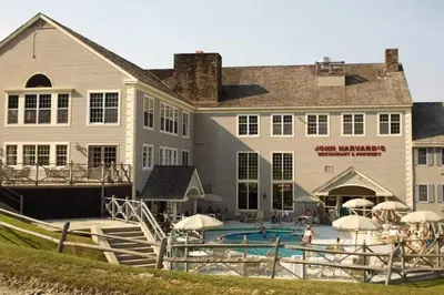a large building with a swimming pool in front of it at Mountain View Suite at Jiminy Peak - Ski On Off - Near Elevator Pool and Lobby in Hancock