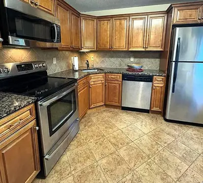 a kitchen with wooden cabinets and stainless steel appliances at 2 BR Condo Mountain Views At Jiminy Peak- Sleeps 7 in Hancock
