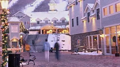 a person walking past a white van parked in a courtyard at 2 BR Condo Mountain Views At Jiminy Peak- Sleeps 7 in Hancock