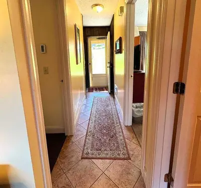 a hallway with a rug on the floor of a house at 2 BR Condo Mountain Views At Jiminy Peak- Sleeps 7 in Hancock