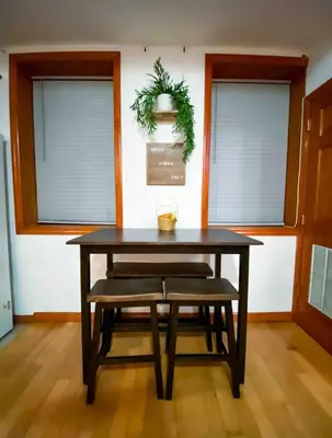a dining room table with a bench and two windows at La Quinta Loft in Long Island City