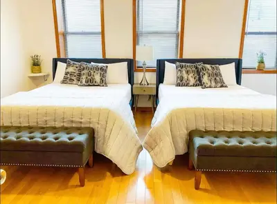 a bedroom with two beds and a couch at La Quinta Loft in Long Island City