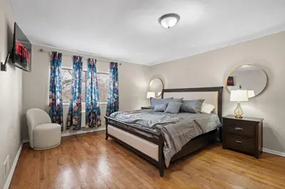 a bedroom with a bed and a chair and a mirror at Uptown Escape in Mount Vernon