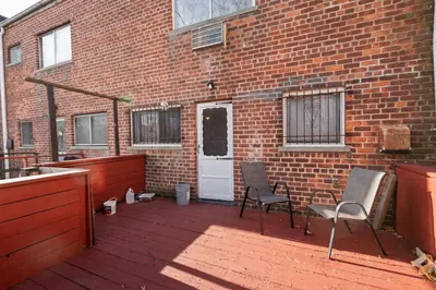 a patio with two chairs and a brick building at Uptown Escape in Mount Vernon