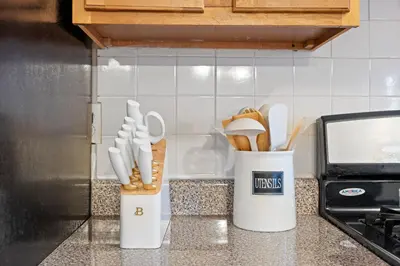 two white containers of utensils on a kitchen counter at Uptown Escape in Mount Vernon