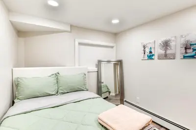 a bedroom with a bed and a mirror at 14 Mi to Central Park Chic Mt Vernon Retreat in Vernon Park