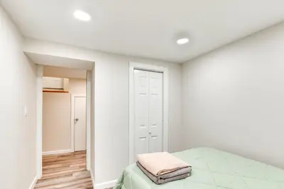 a white bedroom with a bed and a closet at 14 Mi to Central Park Chic Mt Vernon Retreat in Vernon Park