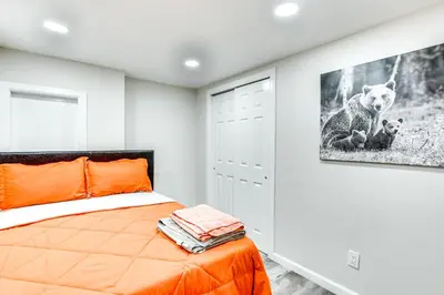 a bedroom with an orange bed and a picture of a dog at 14 Mi to Central Park Chic Mt Vernon Retreat in Vernon Park