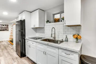 a kitchen with white cabinets and a stainless steel refrigerator at 14 Mi to Central Park Chic Mt Vernon Retreat in Vernon Park