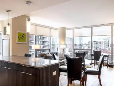a living room with chairs and tables and windows at Luxury Apt with Gym Downtown in Stamford