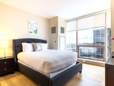 a bedroom with a large bed and a large window at Luxury Apt with Gym Downtown in Stamford