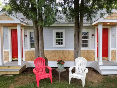 two red and white chairs in front of a house at Saratoga Cabins in Malta