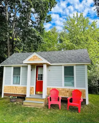 two red chairs in front of a small house at Saratoga Cabins in Malta