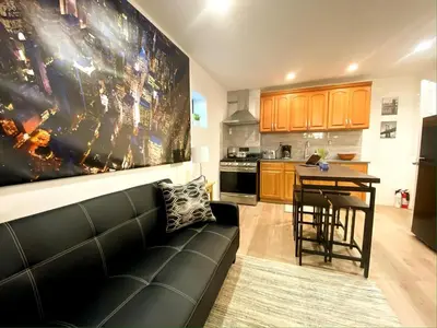 a living room with a couch and a kitchen at Rayhaan Palace in Long Island City