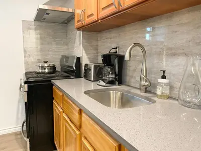 a kitchen counter with a sink and a stove at Rayhaan Palace in Long Island City