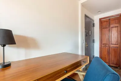 a room with a wooden desk and a blue chair at Onix Studio in Long Island City
