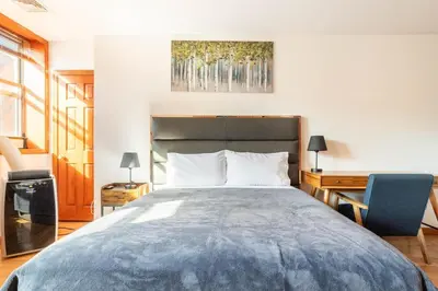 a bedroom with a large bed with a desk and a chair at Onix Studio in Long Island City