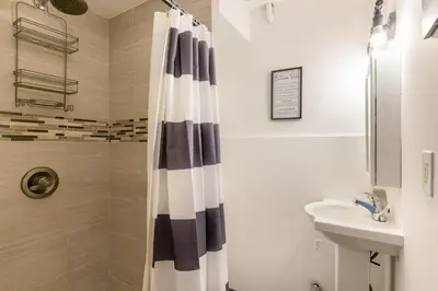 a bathroom with a shower curtain and a sink at Onix Studio in Long Island City