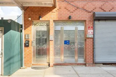 a brick building with two doors and a gate at Onix Studio in Long Island City