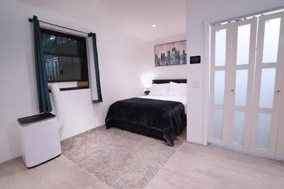 a bedroom with a bed and a window and a door at Bocca Studio in Long Island City