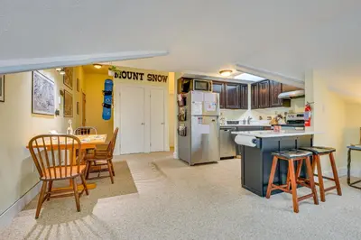 a kitchen and dining room with a table and chairs at Walk to Mount Snow Resort Unit with Pool and Hot Tubs in Dover