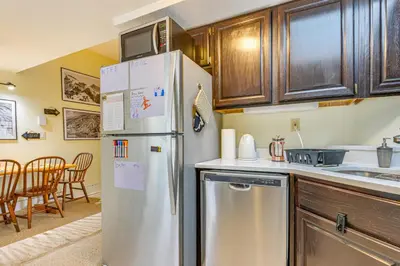 a kitchen with a stainless steel refrigerator and cabinets at Walk to Mount Snow Resort Unit with Pool and Hot Tubs in Dover