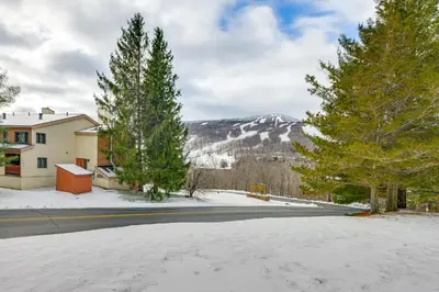a snow covered street in front of a house at Walk to Mount Snow Resort Unit with Pool and Hot Tubs in Dover