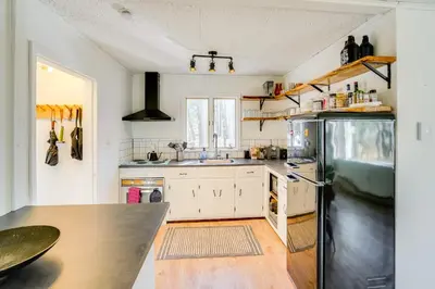 a kitchen with white cabinets and a black refrigerator at Mtn Views and On-Site Hiking Trails Catskills Cabin in Round Top